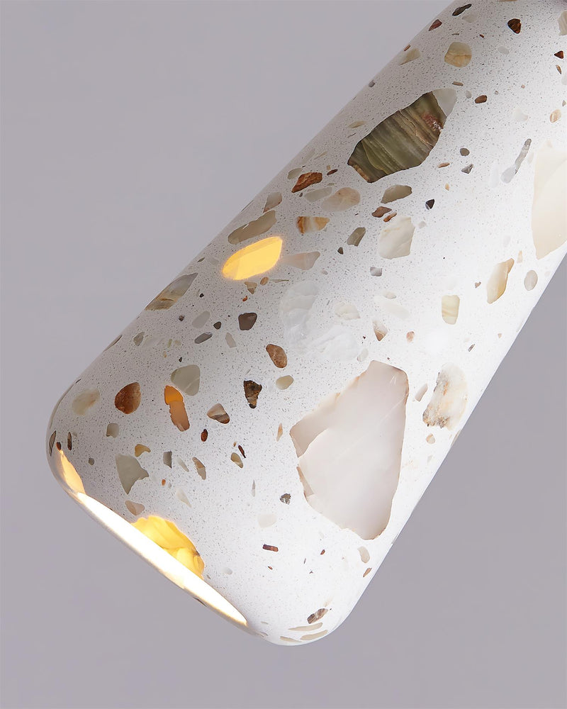 Close-up of the GROTTA No.01 terrazzo pendant light totem, tapered cone with translucent flecks, lit