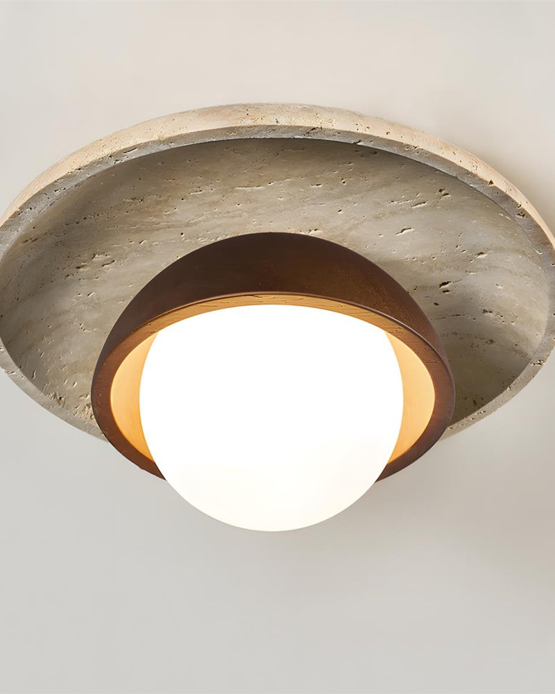 Close-up of the travertine flush mount ceiling light LUNA No.03 with its layered stone disc, walnut dome and lit globe