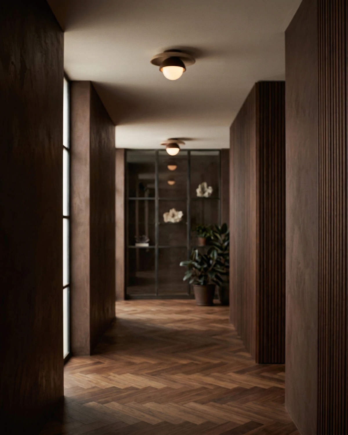 Travertine flush mount ceiling light LUNA No.03 lit along a dark walnut paneled hallway with herringbone floors