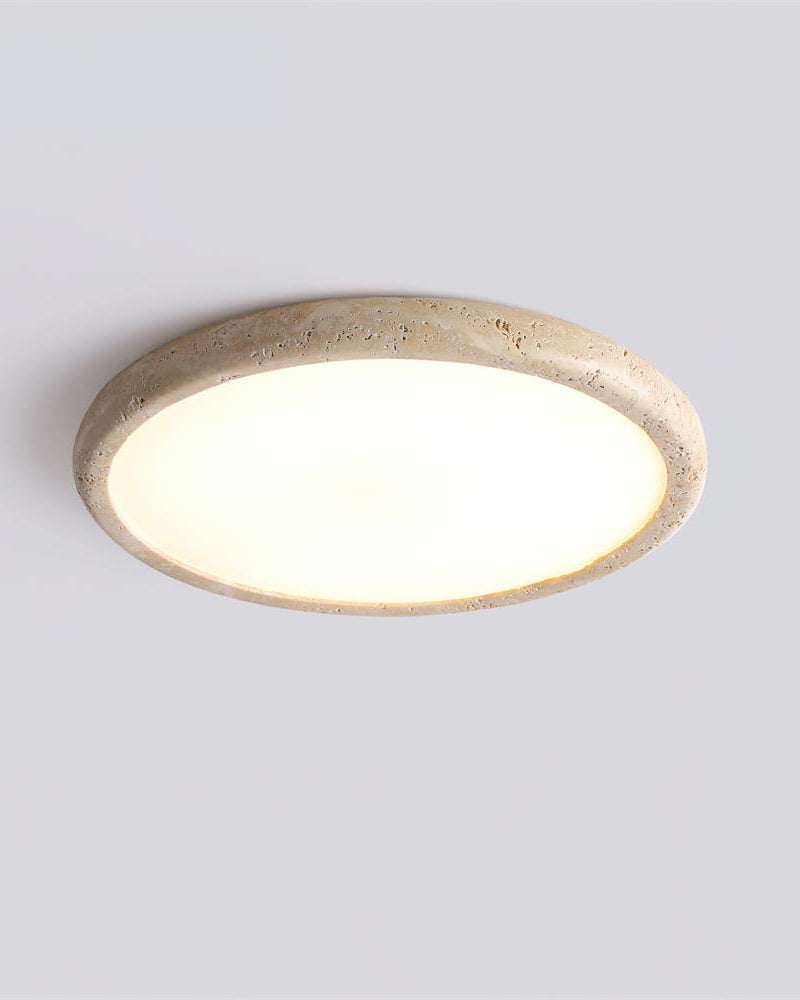 Travertine flush mount ceiling light LUNA No.05, medium size disc lit on a white ceiling, angled view