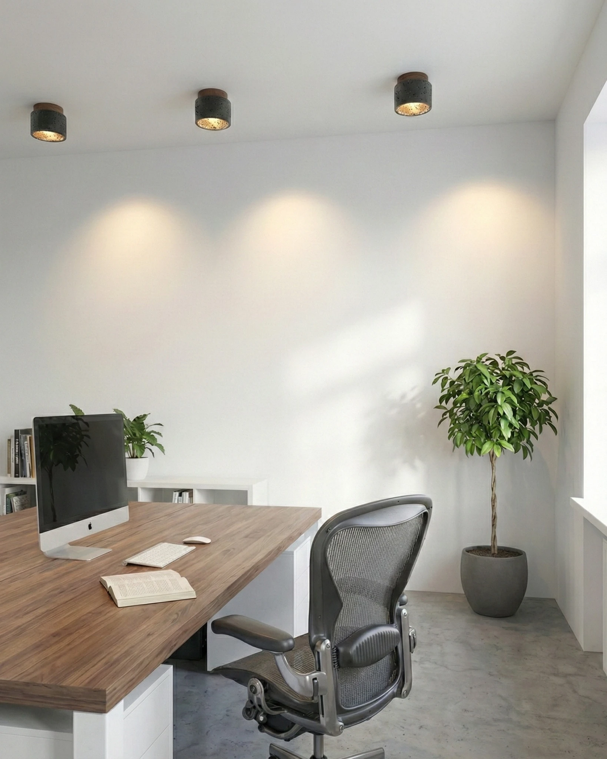 Black travertine flush mount ceiling lights VERTIN No.05, three lit units washing a white office wall above a desk
