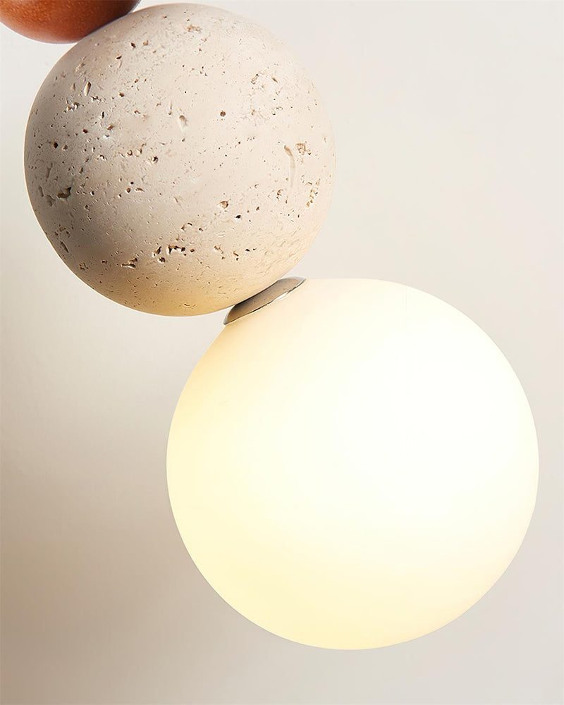 Close-up of the travertine sphere and the glowing opal globe of the travertine pendant light DOMUS No.04