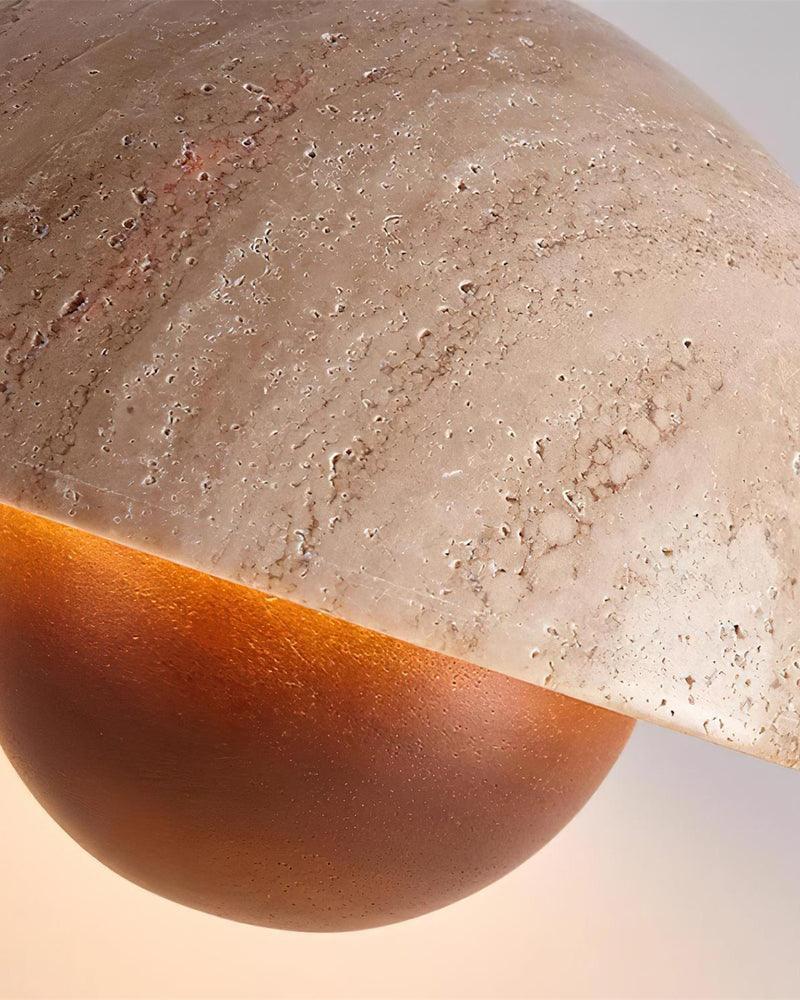 Close-up of the SOLE No.01 travertine pendant light, warm glow spilling from the dome onto the walnut sphere