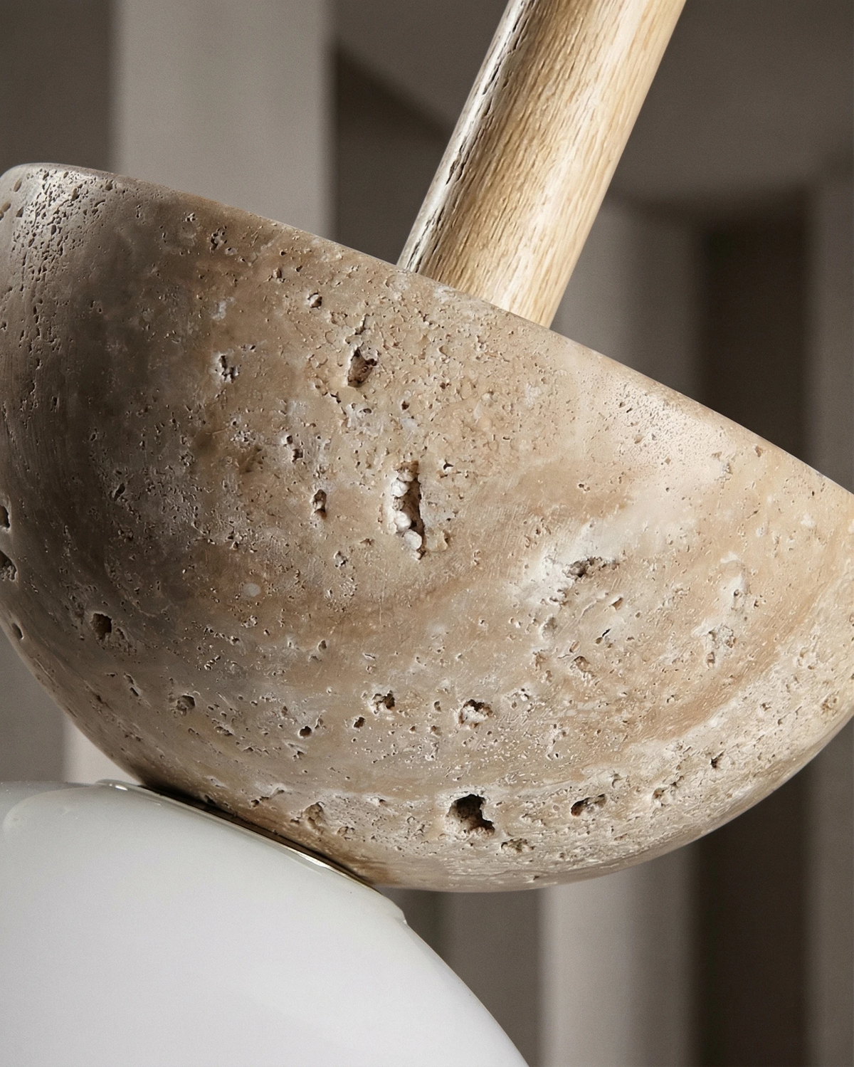 Close-up of the travertine dome and wood stem of the SOVA No.04 travertine pendant light