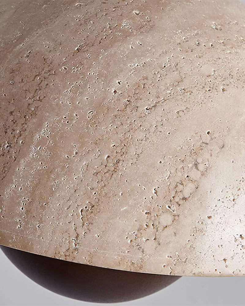 Close-up of the SOLE No.01 travertine pendant light, unlit pitted travertine dome above a dark walnut sphere
