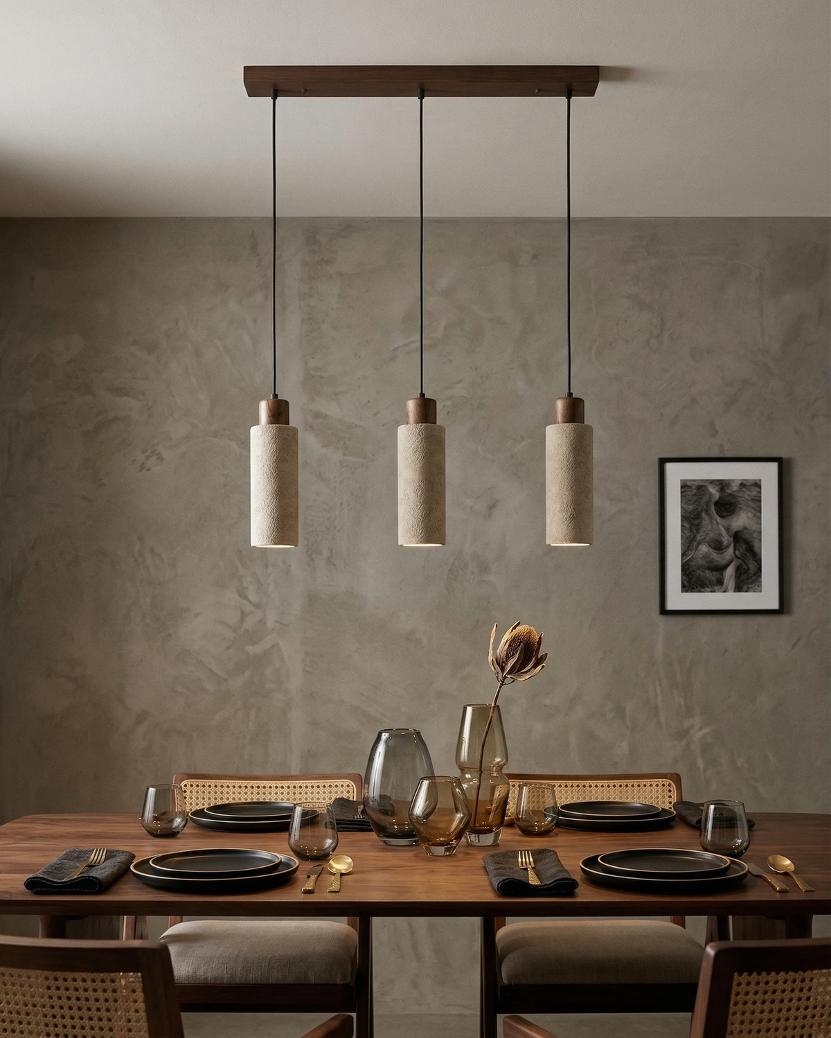 Travertine pendant light CORTO No.03 linear trio, three cream cylinders on a walnut bar above a walnut dining table