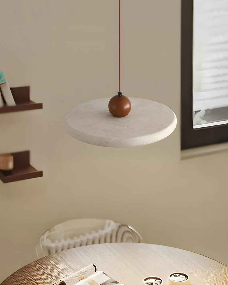 Travertine pendant light TONDO No.02 with a walnut ball hanging over a small round table set with dishes