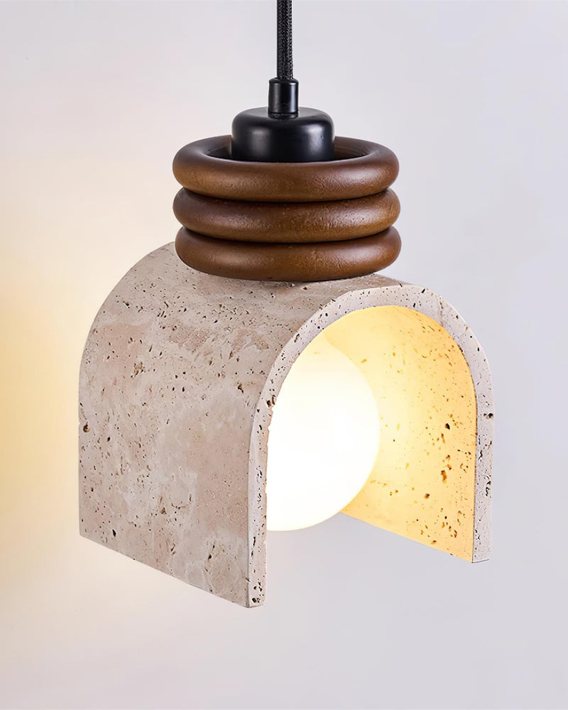 Travertine pendant light ARCA No.02 switched on, angled view of the arched stone shade and walnut ring collar