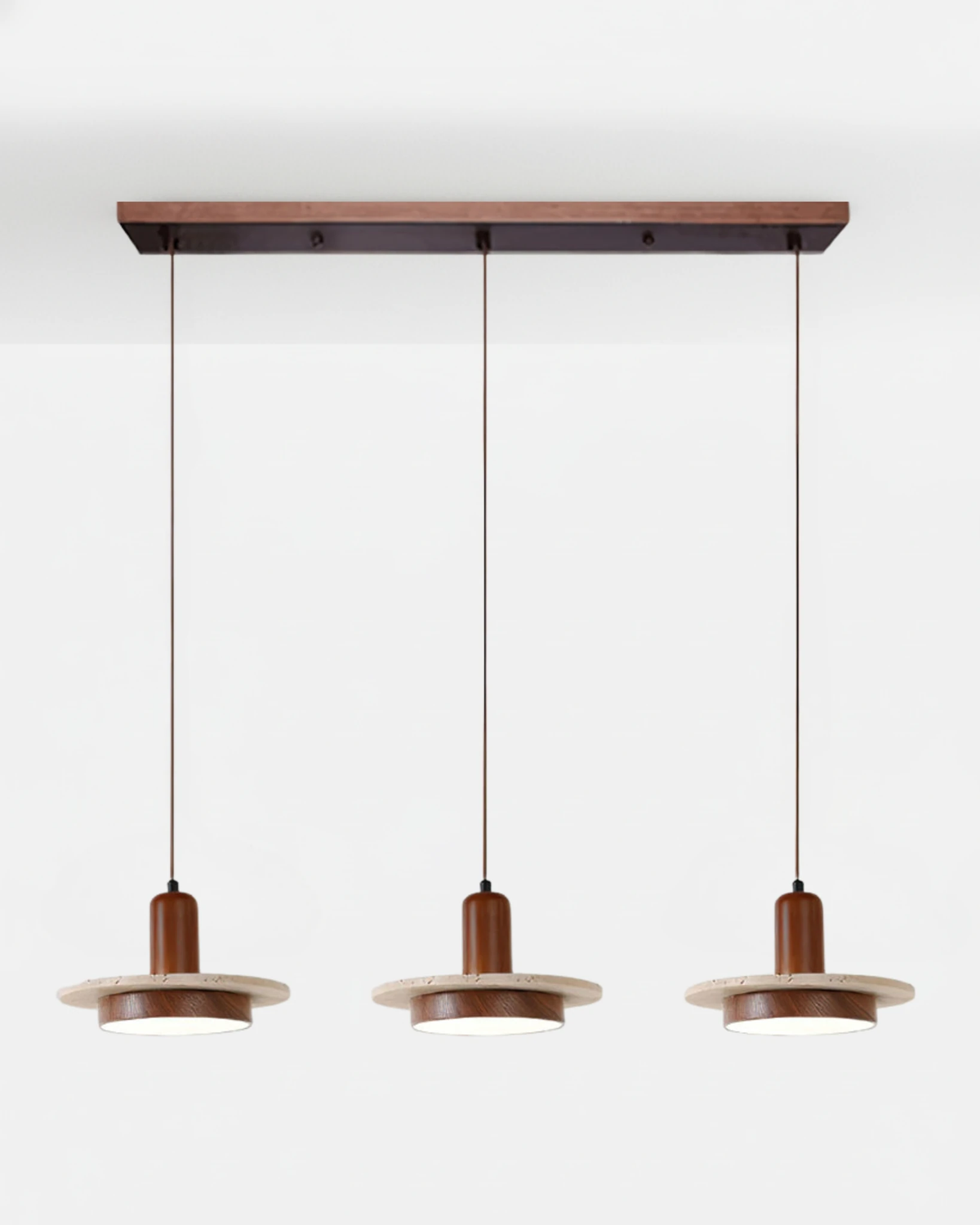 Travertine pendant light SOVA No.02 Triple in Dark Walnut, three lit travertine discs hanging from a walnut bar