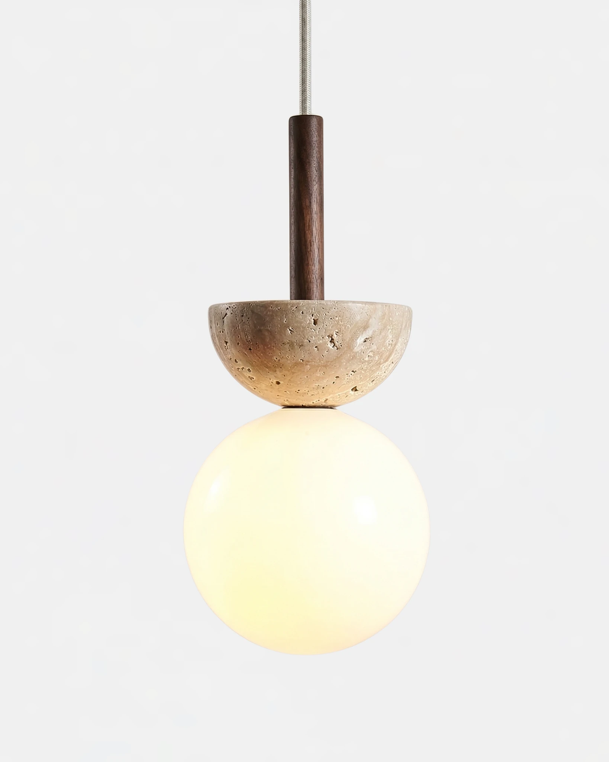 Travertine pendant light SOVA No.04 with walnut stem, stone dome above a glowing opal glass globe