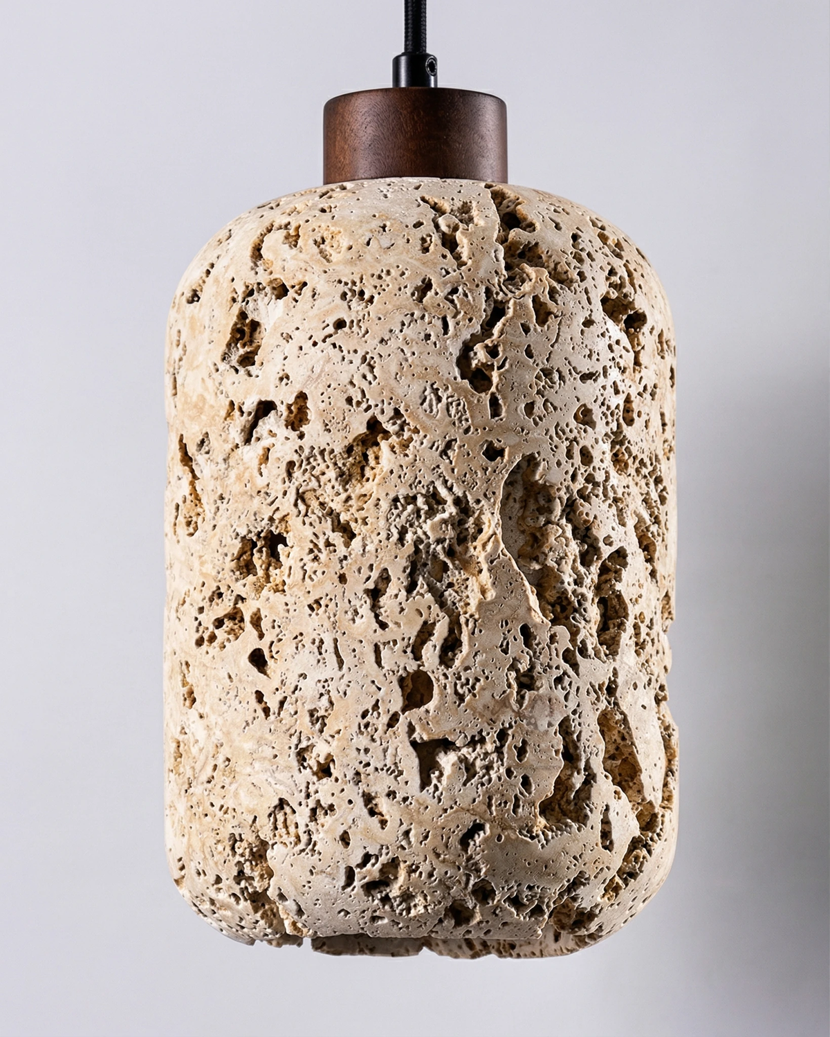 Travertine pendant light MASSA No.01, unlit alveolar travertine cylinder with a walnut canopy on a black cord