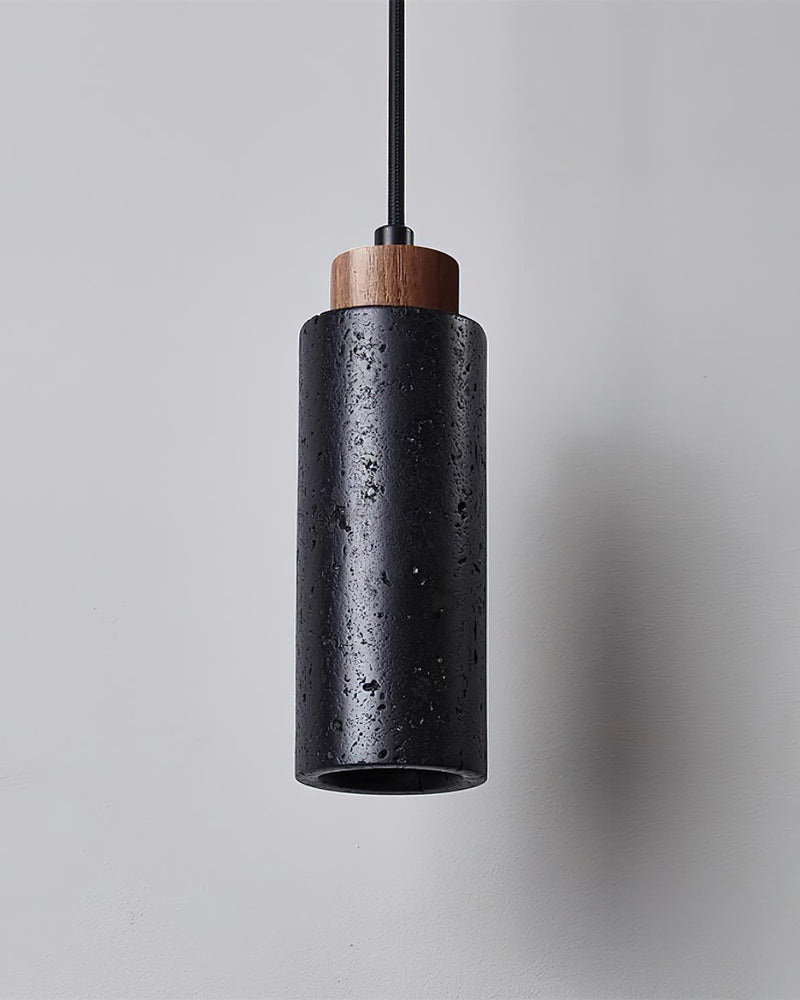 Travertine pendant light CORTO No.03 in Volcano Black, pitted dark cylinder with walnut cap on a black cord, unlit