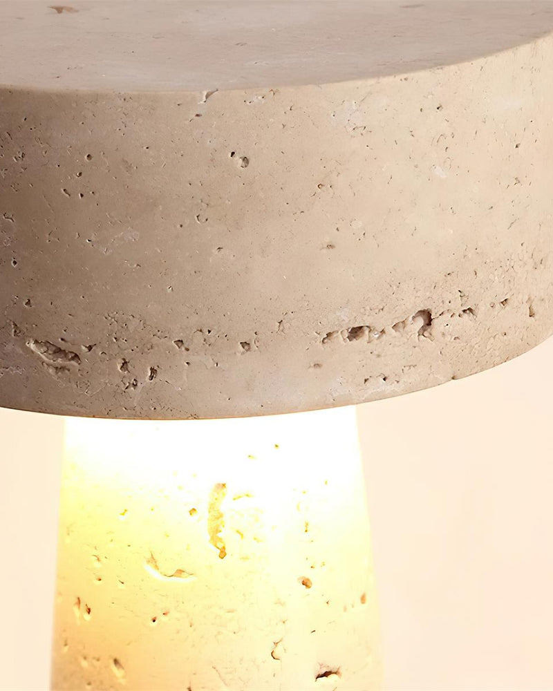 Close-up of the underside of the travertine table lamp MORA No.02 disc glowing warm light down the stem