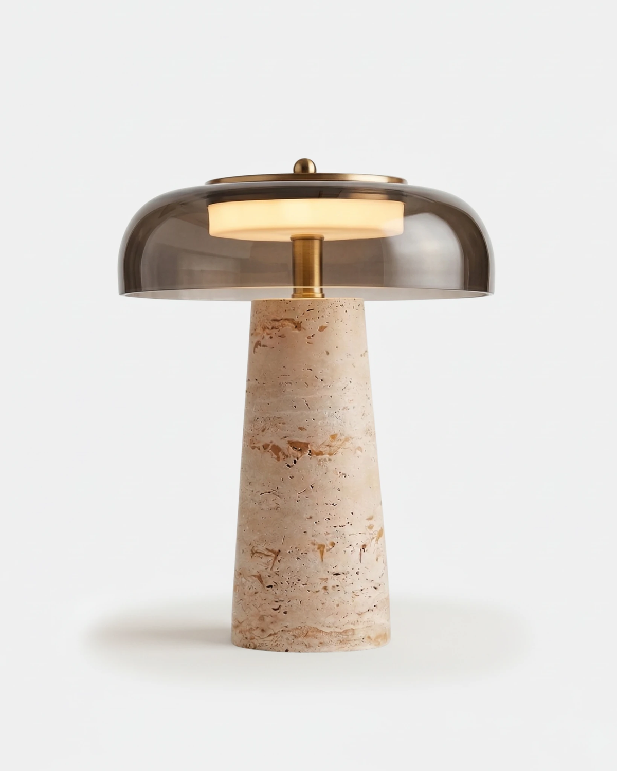 Travertine table lamp MORA No.01 in Travertine and Smoky Gray Glass, tinted dome glowing over the tapered stone base