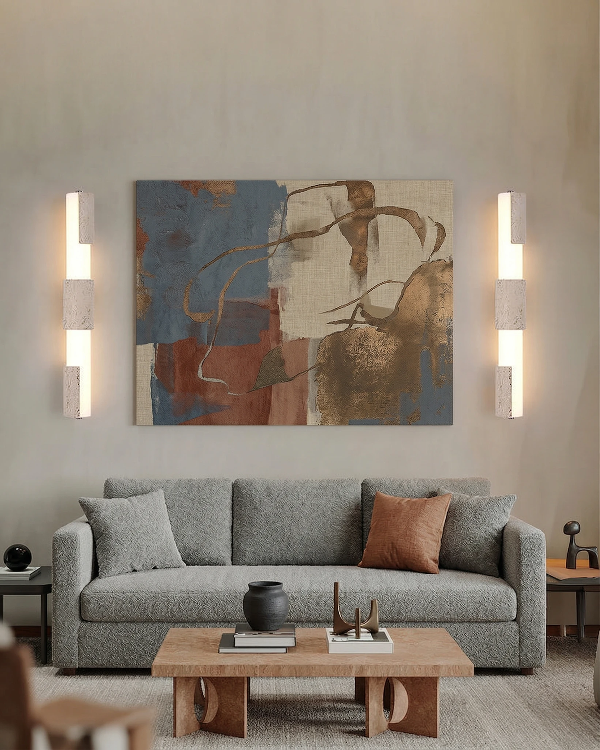 Pair of travertine vanity lights NOTTI No.01 lit flanking a colorful abstract painting above a grey sofa