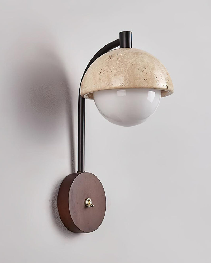 Travertine wall sconce AVORIO No.03 angled view, stone dome and frosted globe on a curved black arm, unlit