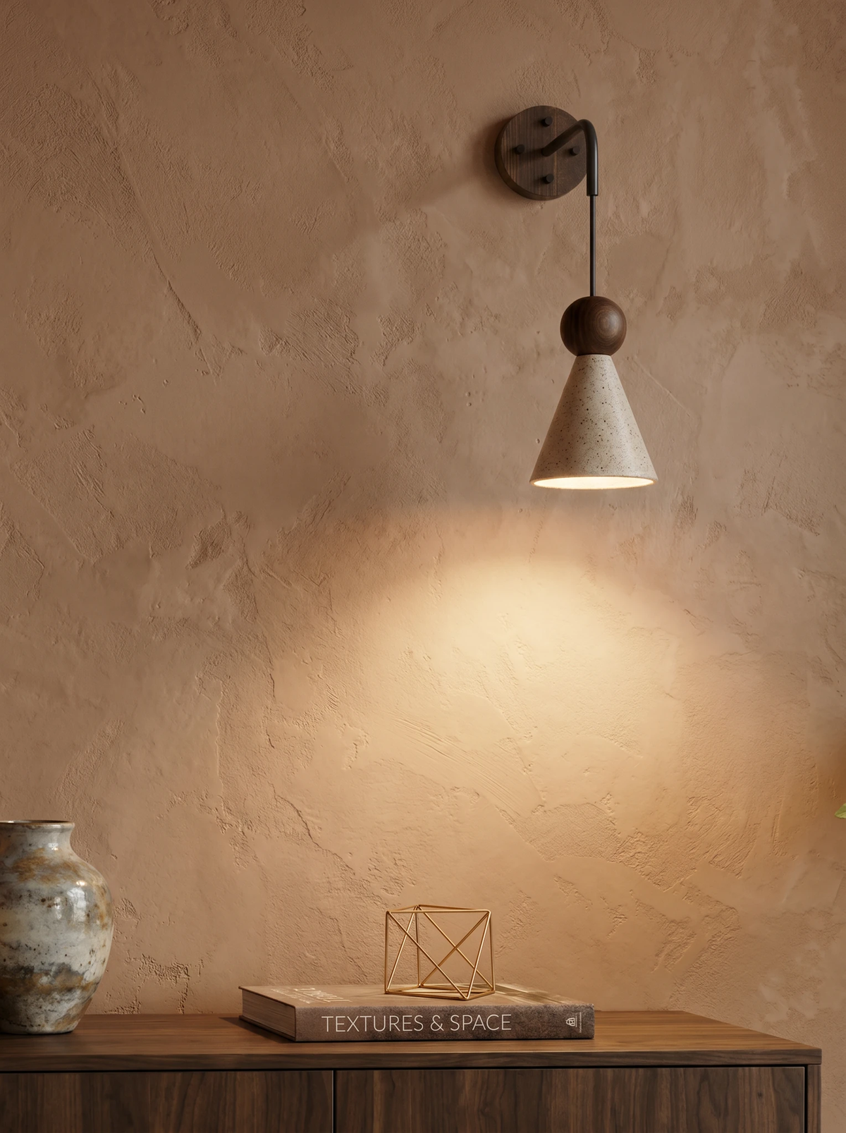 Travertine wall sconce CORTO No.01 casting warm light down a textured beige wall above a walnut console with a vase