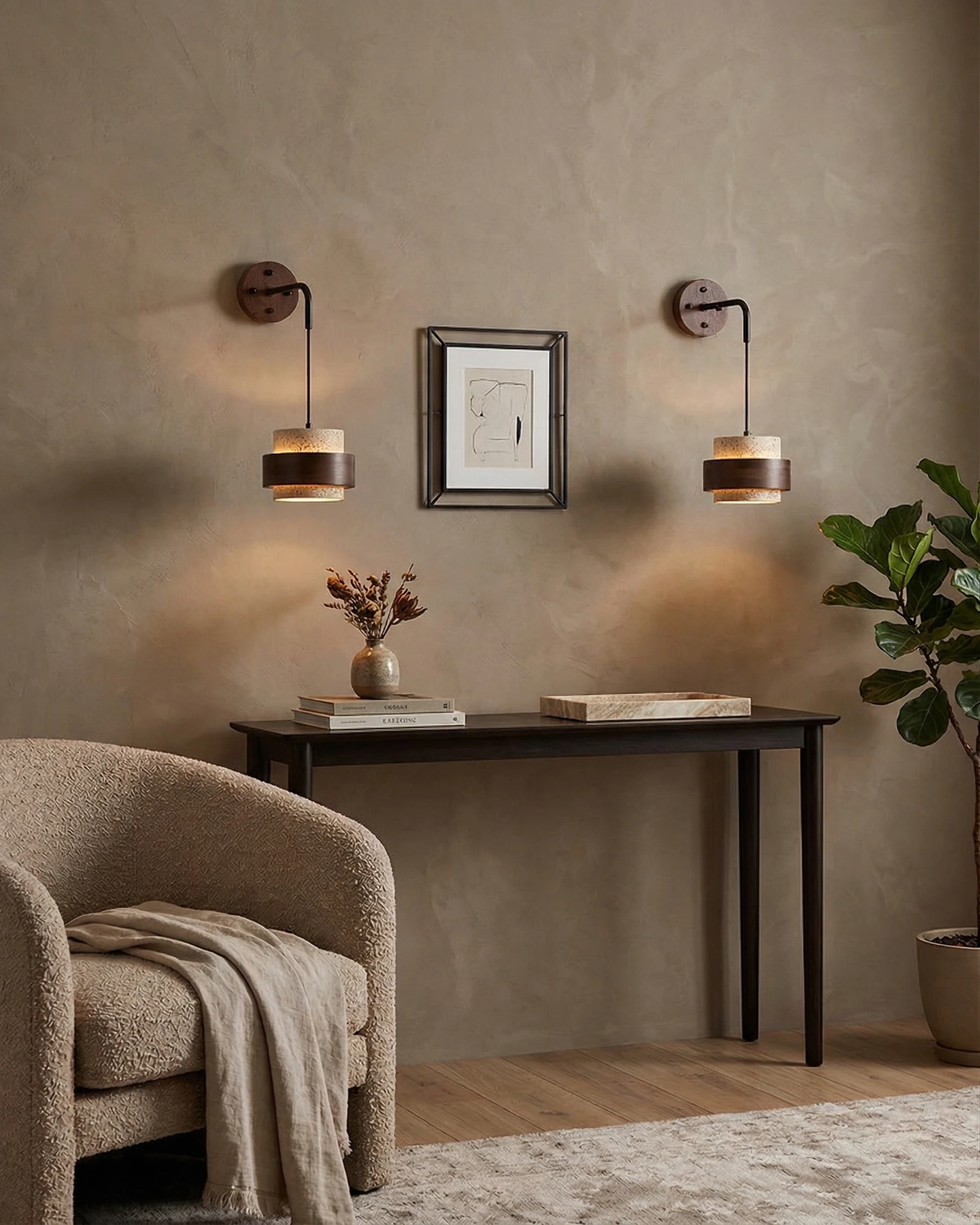 Two travertine wall sconces TIVOLI No.02 lit flanking a framed print above a black console table