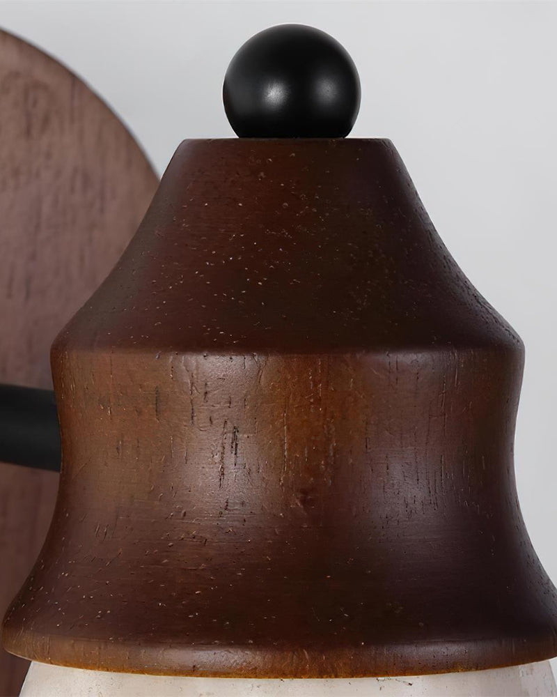 Close-up of the walnut cone fitting and black ball knob of the CONA No.03 travertine wall sconce