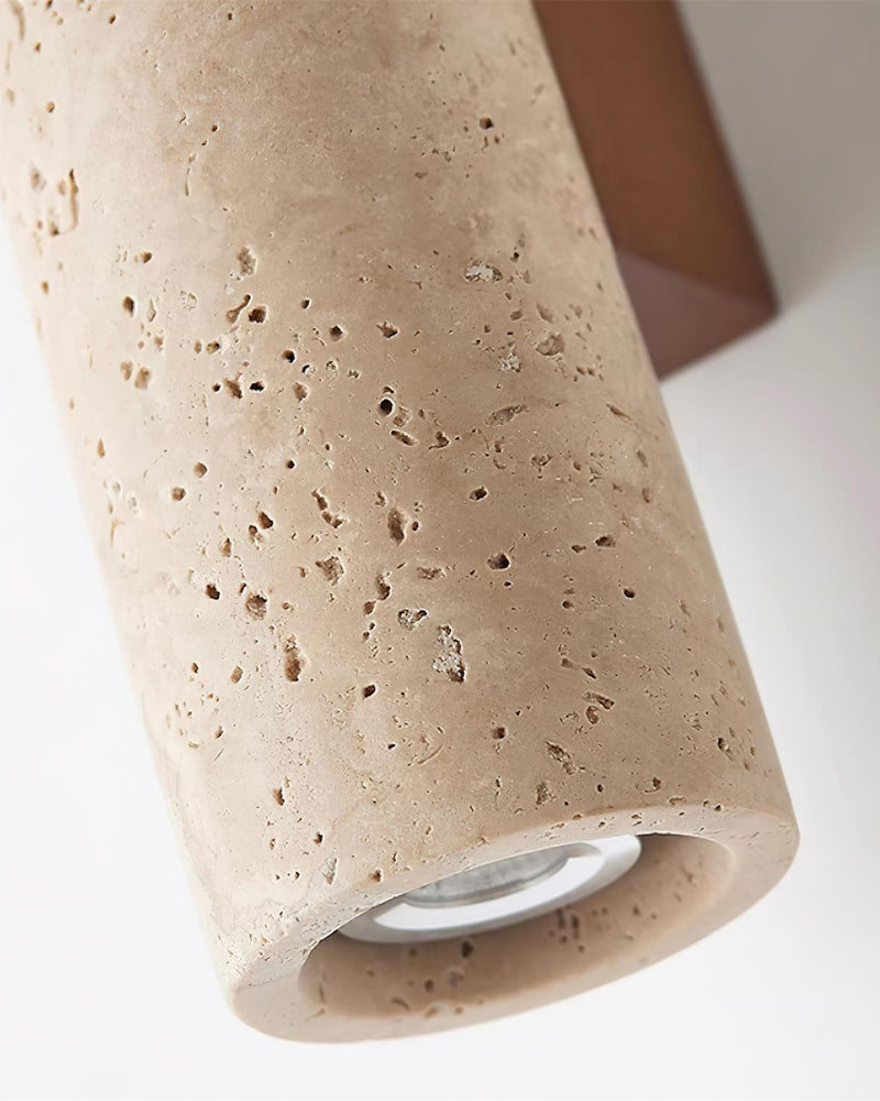 Close-up of the bottom of the travertine wall sconce STELO No.02 column showing the downlight lens