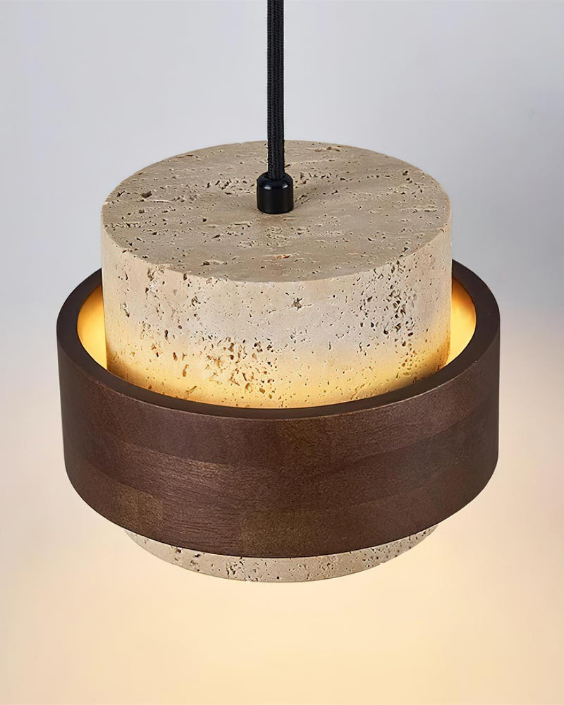 Close-up of the travertine wall sconce TIVOLI No.02 drum on its black cord with warm light spilling from the base