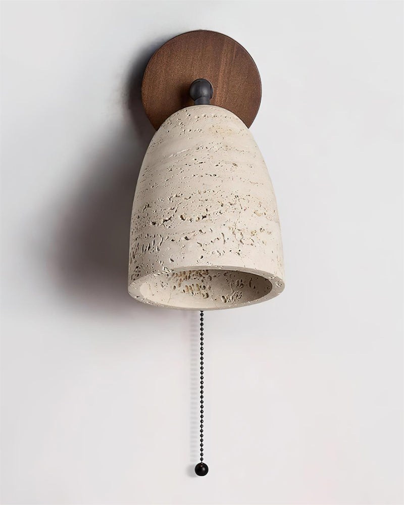 Travertine wall sconce PERA No.01 seen from below with the lit dome opening and hanging pull chain