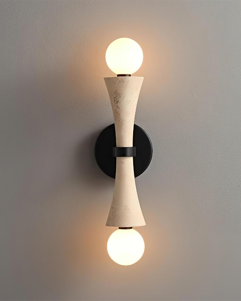Travertine wall sconce VETTA No.01 switched on, twin opal globes glowing above and below the cream stone body