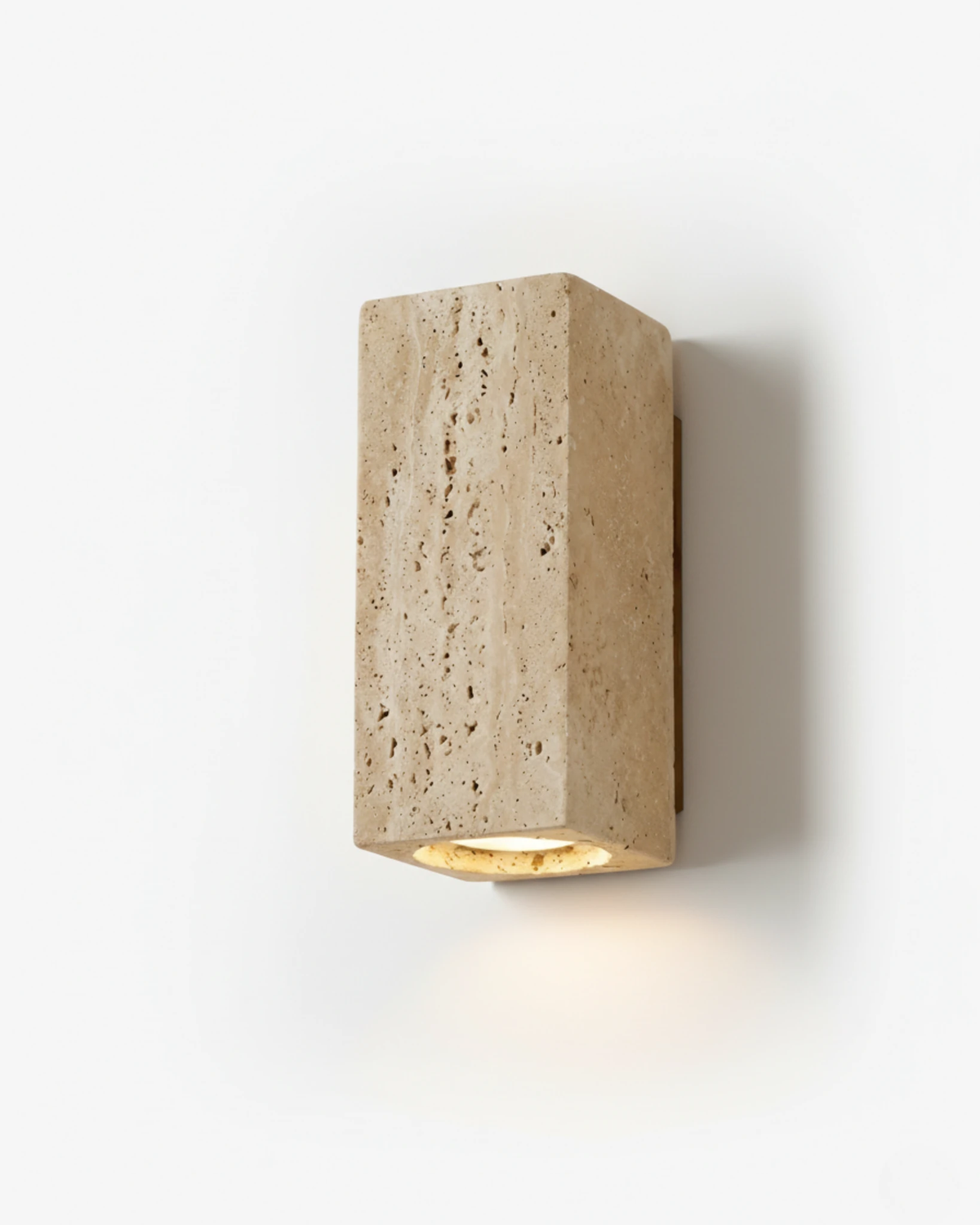 Travertine wall sconce GRANO No.01, rectangular yellow travertine block lit downward on a white wall