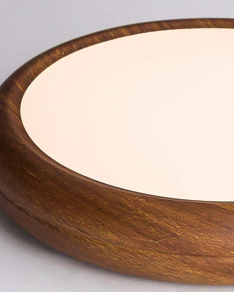 Close-up of the rounded wood grain rim and warm lit diffuser of the COMO No.01 flush mount