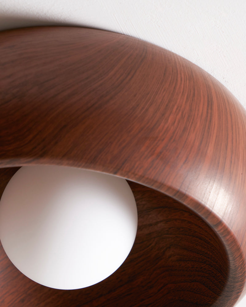 Close-up of the rim and opal bulb of the OMBRA No.01 wood flush mount ceiling light in dark walnut