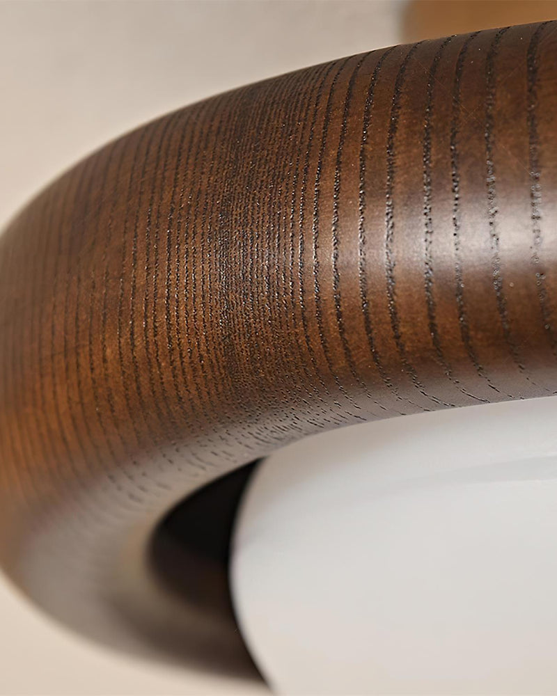 Close-up of the walnut halo of the MURA No.01 wood flush mount ceiling light showing the grain and opal edge