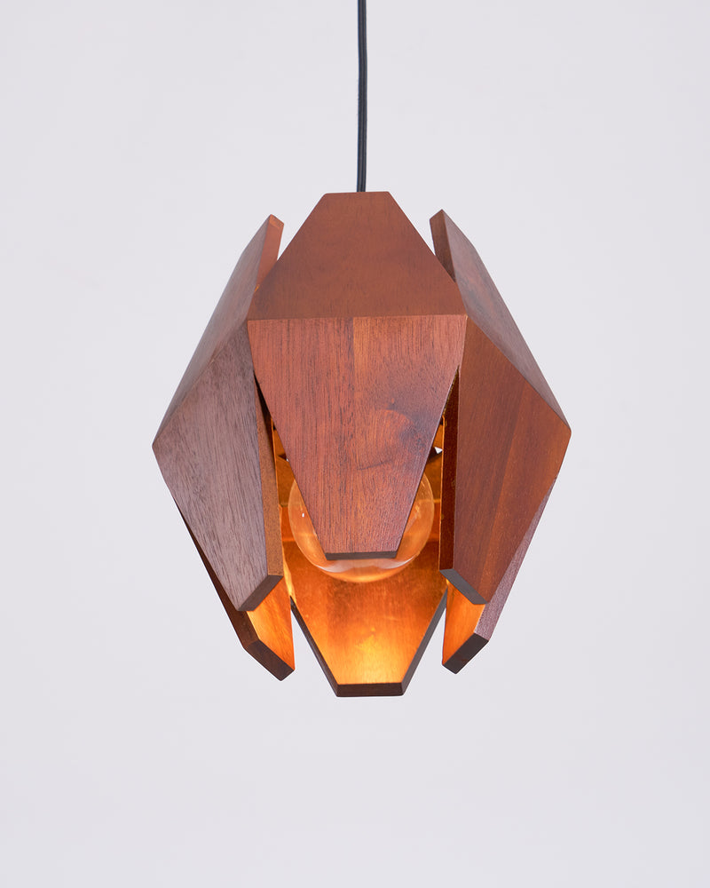 Wood pendant light ORBIT No.01 from below with the light on, amber glow between the faceted walnut fins