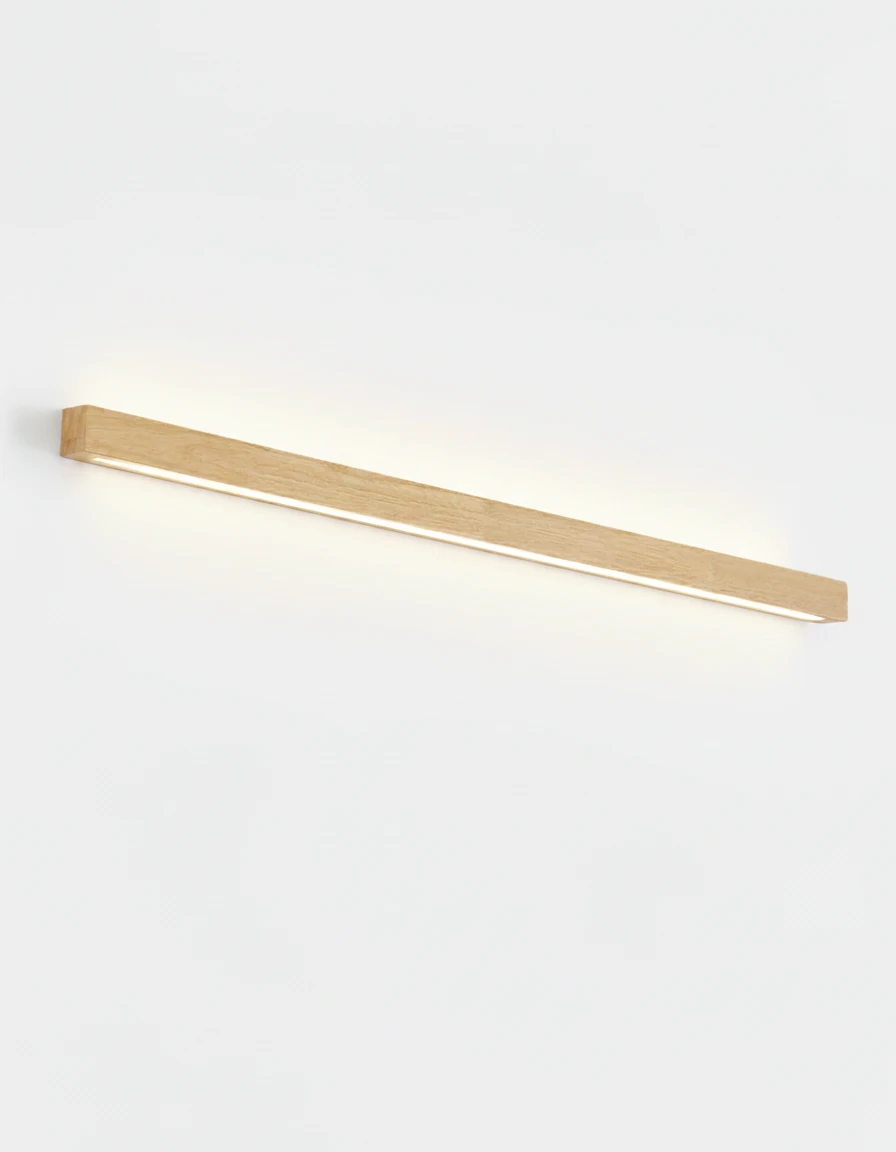 Wood wall sconce PIANO No.01 in light walnut, 100 cm bar with an up-and-down LED, switched on